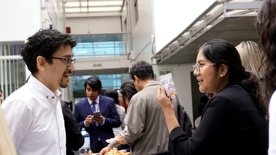 Dos asistentes conversan durante un espacio de networking en el patio del congreso.