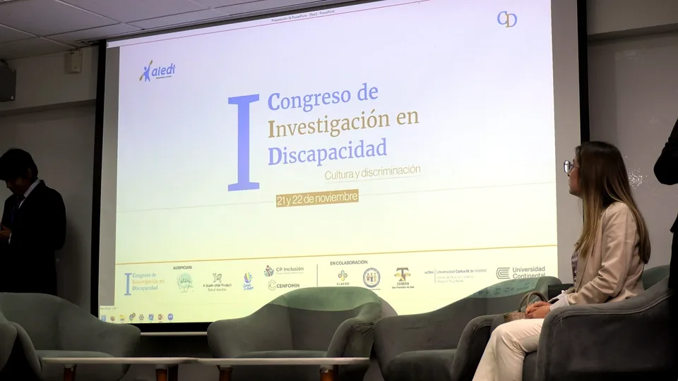 Escenario vacío del Congreso de Investigación en Discapacidad con una pantalla de presentación proyectada al frente.