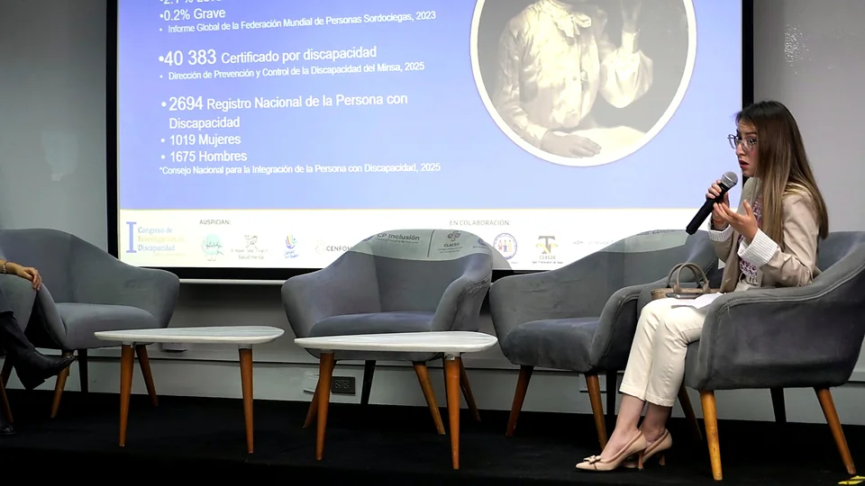 Una participante interviene con un micrófono desde un sillón en el escenario, durante un espacio de diálogo del congreso.